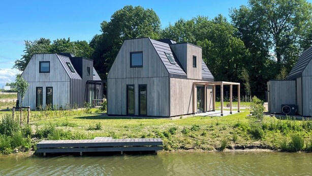 A modern house with a large deck and a dock extending into a body of water. - Stay in complete comfort in this modern, recently built holiday home with beautiful views of the wat (Oude-Tonge)