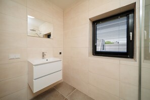 A bathroom with a white sink, a mirror, and a window with blinds. - Stay in complete comfort in this modern, recently built holiday home with beautiful views of the wat (Oude-Tonge)