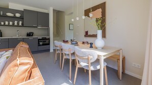 Eine moderne Küche mit grauen Schränken, einem Holztisch und einer Bank.