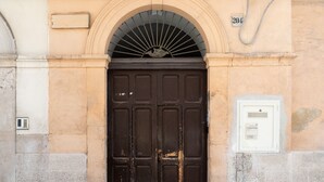 Une porte double marron, avec une plaque portant le numéro « 204 » au-dessus.