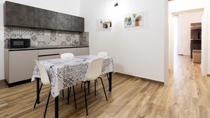 Une cuisine compacte équipée d’un four à micro-ondes, d’un crédence décorée et d’une table à manger avec des chaises.