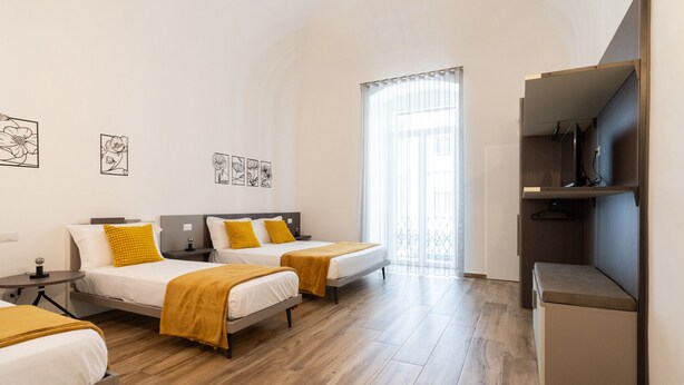 Une chambre d’hôtel moderne équipée de deux lits, d’un bureau et d’une armoire.