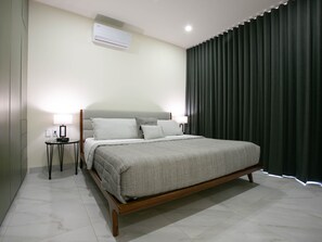 A modern bedroom with a large bed, bedside tables, an air conditioning unit, and a dark curtain. - Casa Lumar in Cabo San Lucas (Cabo San Lucas)