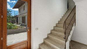 Un escalier avec une rampe en bois et des marches de couleur beige menant à un palier.