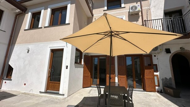 Un bâtiment doté d’un balcon, d’une porte et d’une fenêtre.