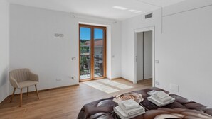 Une chambre à coucher comprenant un lit, une chaise, une porte coulissante et donnant sur l’extérieur.