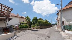 A quiet residential street with houses, a clear sky, and a palm tree. - Suite Le Orchidee with Mountain View, Wi-Fi and Air Conditioning (Agerola)