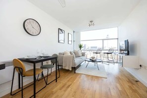Un salon moderne comprenant un coin repas, un canapé, une table basse et un téléviseur.
