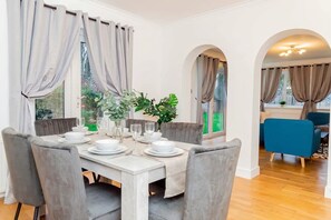 Een eetgedeelte met een tafel voor vier personen, omringd door grijze fauteuils.