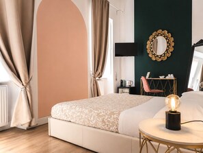 Une chambre à coucher avec un lit, une table ronde avec une lampe, un miroir et un bureau avec une chaise.