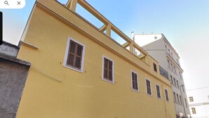 Un edificio amarillo con varias ventanas y un balcón.