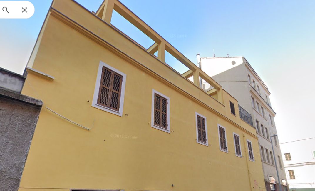 A yellow building with multiple windows and a balcony.