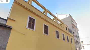 A yellow building with multiple windows and a balcony.