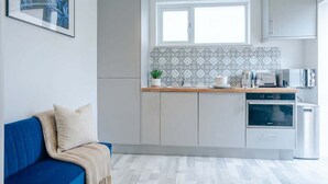 A modern kitchen with a window, cabinets, and a microwave.