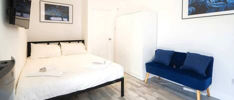 Escritorio, tabla de planchar con plancha, wifi y ropa de cama