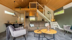 A spacious loft-style living area with a high ceiling, a staircase, a kitchen, and a dining area. - Wonderful private villa for 4 guests with pool, WIFI, A/C, TV, terrace and pets allowed (Apeldoorn)