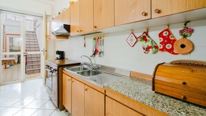 A kitchen with wooden cabinets, a stainless steel sink, and a granite countertop. - Holiday Home 'Simona' with Shared Terrace, Wi-Fi and Air Conditioning (Taviano)