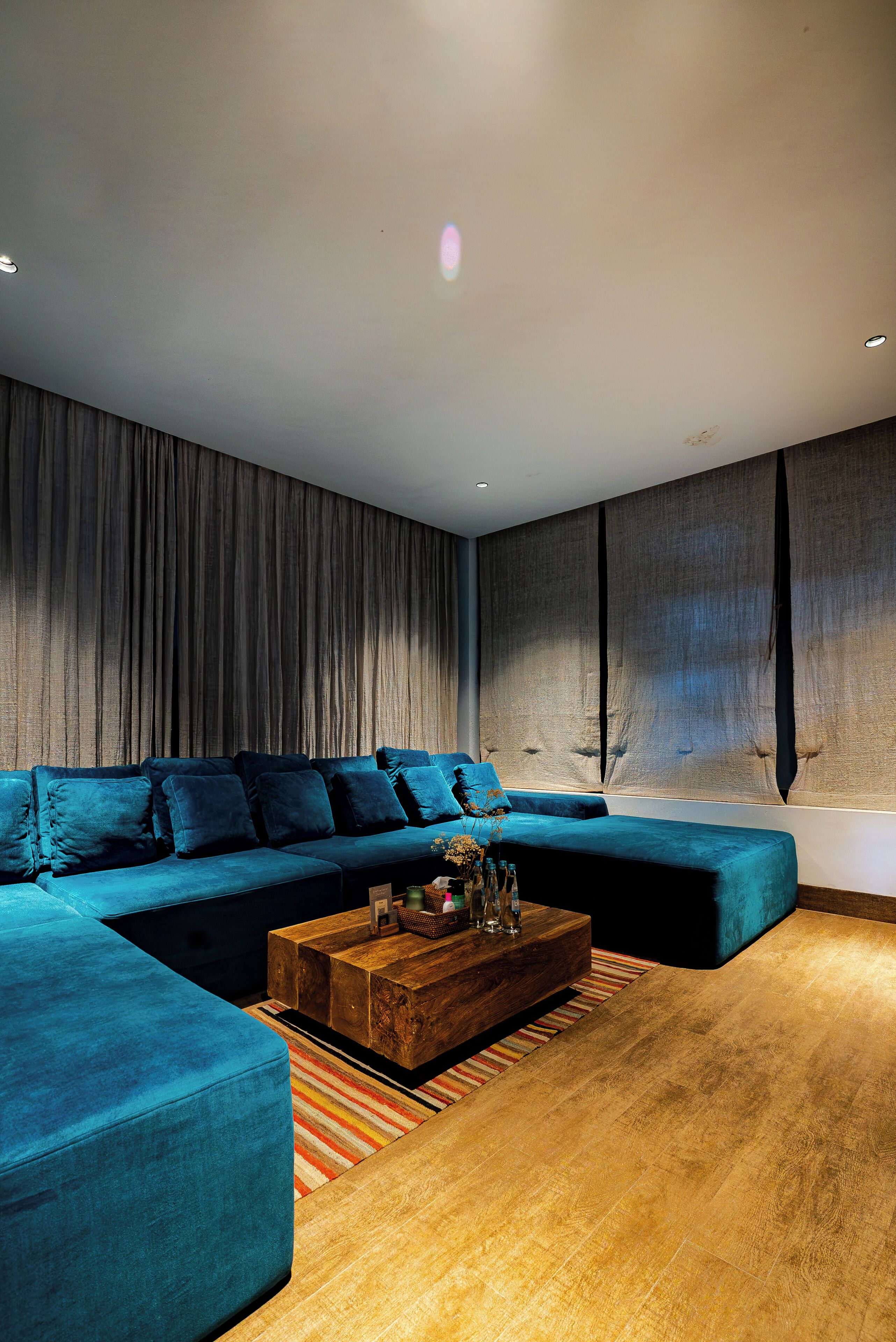 Uma sala de estar moderna com sofá seccional, mesa de centro de madeira e tapete listrado.