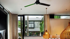 Un dormitorio moderno con una cama grande, un ventilador de techo y vistas al exterior.
