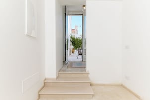 A clean, modern hallway with a glass door leading to an outdoor area.