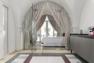 Una habitación de hotel moderna con una cama grande, un escritorio y vistas a través de un ventanal.