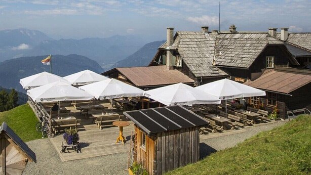 A mountain lodge with outdoor seating and a view of the surrounding mountains. - Mobile Home in Bodensdorf Near Gerlitzen Ski Area (Steindorf am Ossiacher See)