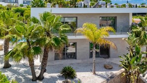 A modern villa with a pool, surrounded by palm trees and a mountainous backdrop. - VILLA EOS luxury villa in a quiet location (Xàbia)