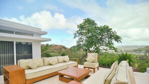 A modern outdoor living area with a sofa, chairs, and a coffee table. - VILLA SEGER LOMBOK (Kuta)