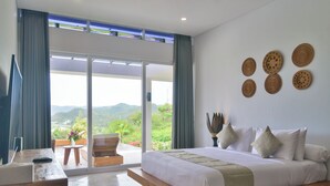 A modern bedroom with a large bed, a desk, and a view of the outdoors. - VILLA SEGER LOMBOK (Kuta)