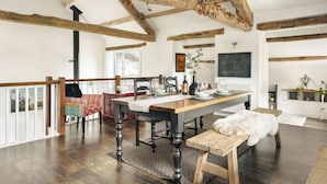 A dining area with a wooden table, chairs, and a bench. There is a dog on the bench. - Jackson's Barn | Ridgestone (Water Yeat)