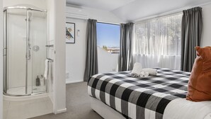 A hotel room with a bed, a shower, and a view of the outdoors. - The Tui`s Nest - central to town (Taupō)