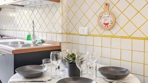 A kitchen with a tiled backsplash, a wooden cutting board, and several bowls and glasses on the counter. - Vatican Area | Stylish 2BR + Fast Wi-Fi & A/C (Roma)