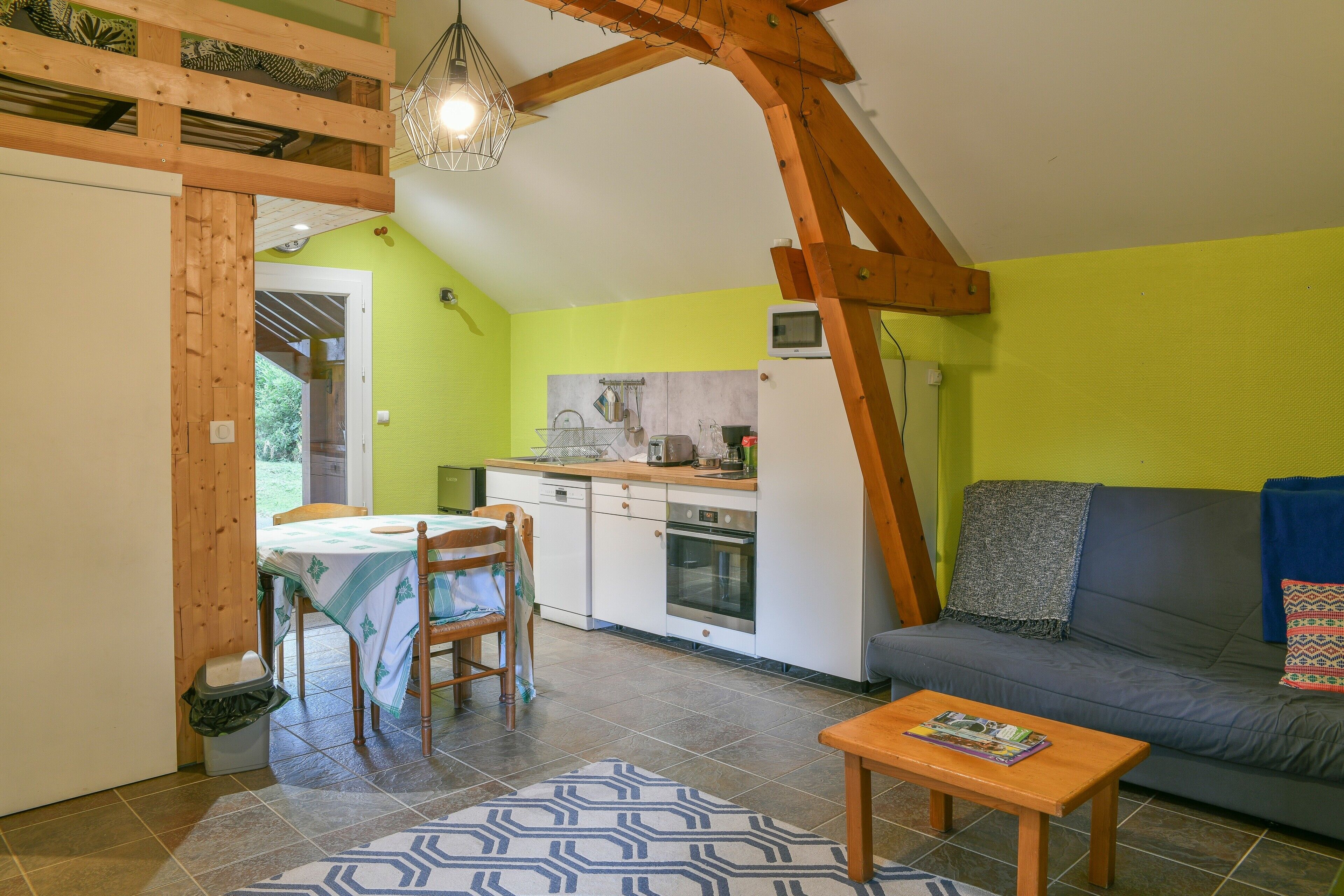A compact living space with a dining area, kitchenette, and seating area.