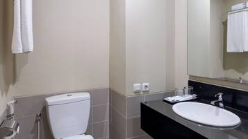 Un bany modern amb un vàter blanc, un lavabo negre i un mirall.