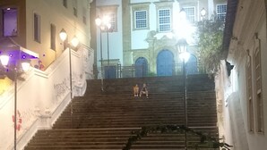 Un conjunto de escalones de piedra que conducen a un edificio de arquitectura ornamentada, incluyendo un amplio arco de entrada y columnas decorativas.