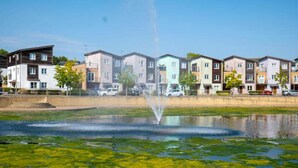 A row of modern multi-story residential buildings with a fountain in the foreground. - 14 Guests-6 Bedroom House, Free Parking (Milton Keynes)
