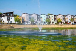 A row of modern multi-story residential buildings with a fountain in the foreground.