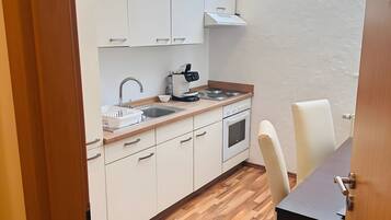 Een koelkast, een oven, een kookplaat, een koffiezetapparaat/waterkoker