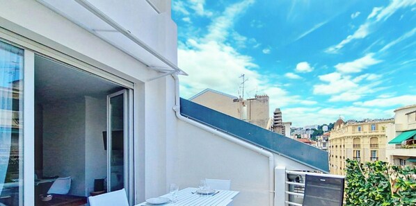 A balcony with a table set for dining, a sliding glass door, and a cityscape view. - N&J - CASA SOLANA - Terrace - Centre (Niza)