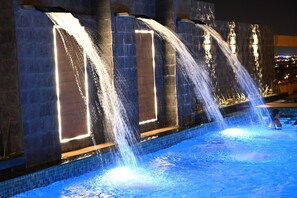 A pool with multiple water features, including cascading water jets and illuminated panels. - Savoy Grande Hotel and Spa (Manama)