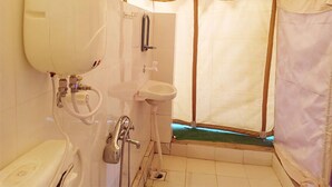 A compact, well-lit bathroom with a toilet, sink, and shower area, enclosed by a tent-like structure. - Great Rann Resort (Bhuj)