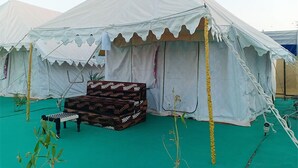 A white tent with a patterned bench and a small table in front. - Great Rann Resort (Bhuj)