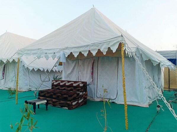 A white tent with a patterned bench and a small table in front. - Great Rann Resort (Bhuj)