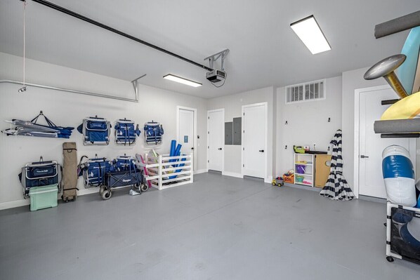 Habitación limpia y bien iluminada con paredes blancas y suelo gris, que incluye equipo médico, un carrito y estanterías.