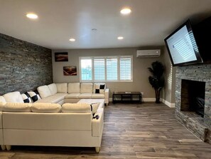 TV, fireplace, books - The Stone Sanctuary @ McCullough Hills Trailhead: 1/2 ACRE, Pool, Grill, Pool Table, 7 TV's, Luxury (Henderson)