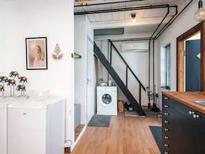 A laundry room with a washing machine, a dryer, and a staircase leading to another level. - 6 Person Holiday Home in Lokken (Lokken)