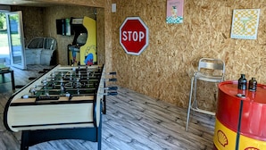 A room with a foosball table, a stop sign, and a wall with a 'MOJITO' sign.
