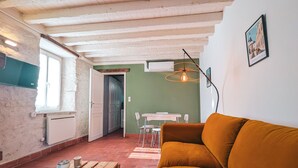 Un salon chaleureux avec une table en bois, un canapé et une table à manger avec des chaises.