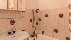 Een badkamer met een wastafel, spiegel en douche.