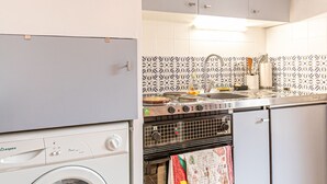 Una cocina compacta con lavadora, estufa y pileta.